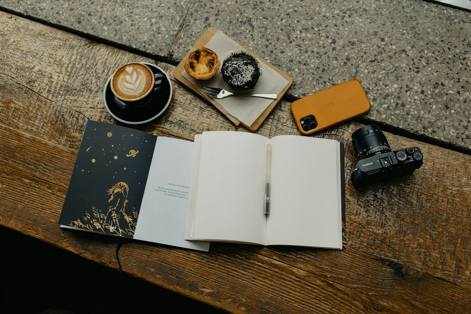 Åpen notisbok ved siden av en kaffekopp på et trebord — en stille morgenrutine.