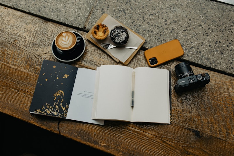 Åpen notisbok ved siden av en kaffekopp på et trebord — en stille morgenrutine.